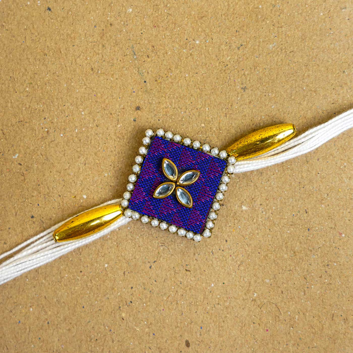Handmade Purple Diamond Fabric And Mdf Rakhi With Roli Chawal - Close-up of centerpiece