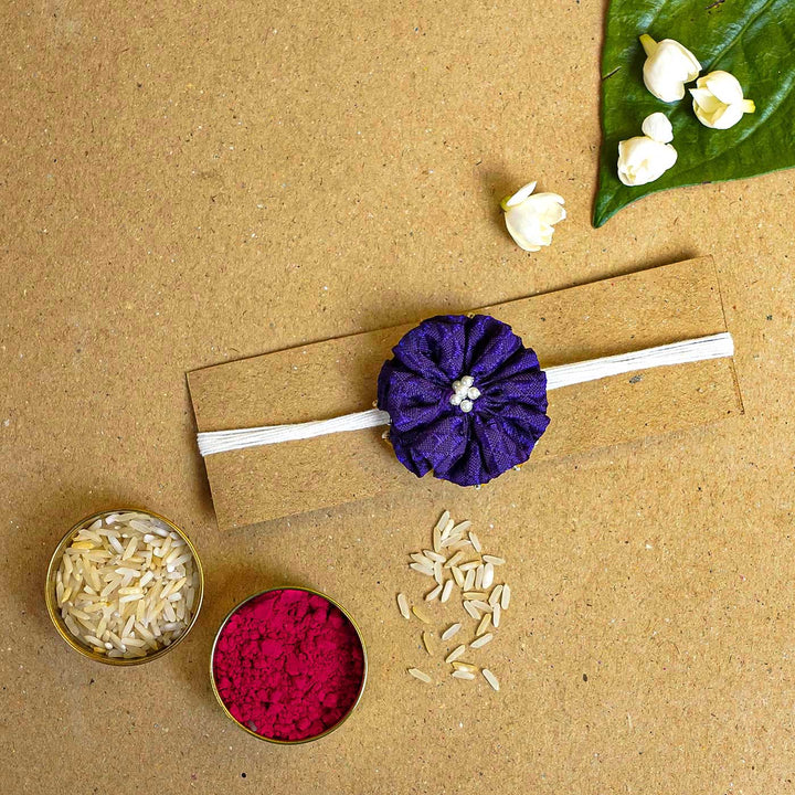 Handmade Purple Floral Fabric Rakhi With Roli Chawal - Band on card with decorations