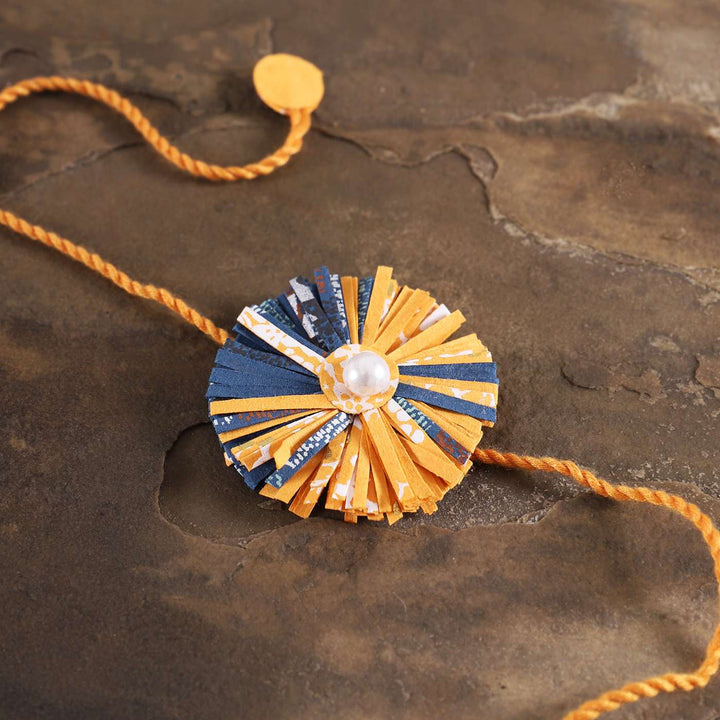 Handmade Ecofriendly Yellow Recycled Paper Rakhi With Roli Chawal - Close-up of Decorative Centerpiece