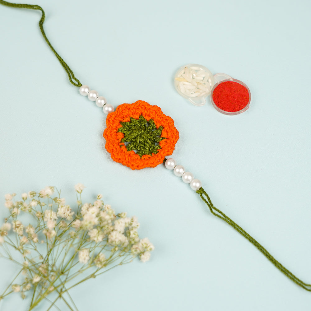 Handmade Crochet Orange Floral And Beads Rakhi With Roli Chawal For Bhaiya Bhabhi And Kids - Flat Lay with Close-up Accessories