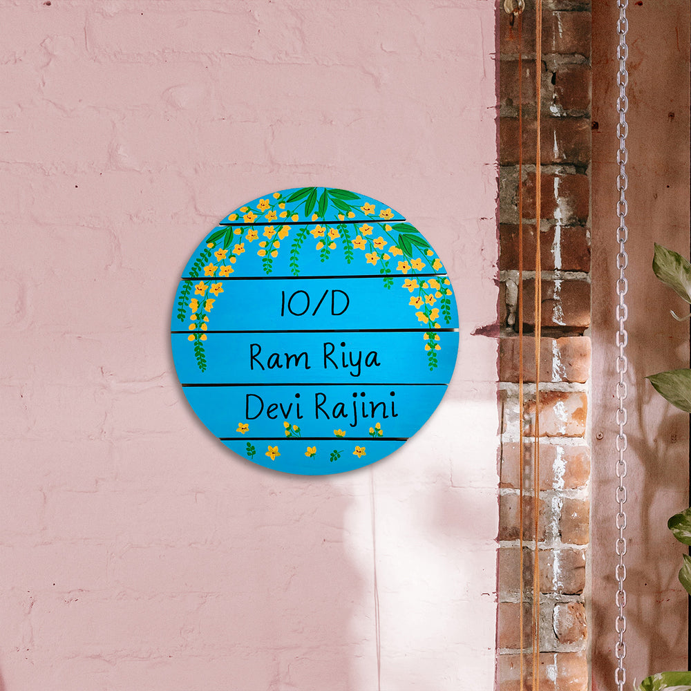 Round Hand Painted Madhubani Art Name Plate 8 - Mounted on Pink Brick Wall