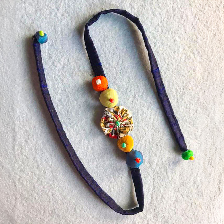 Handmade Beaded Flower And Button Design Upcycled Fabric Rakhi With Roli Chawal For Brother - Flat Lay Display