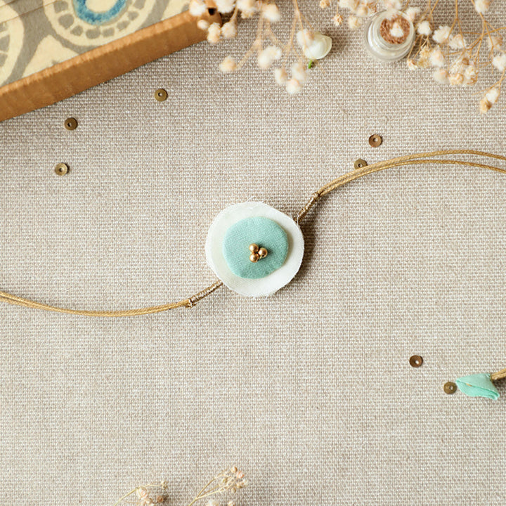 Handmade Reusable Round Layered Petal Beads Upcycled Fabric Rakhi With Roli Chawal For Brother - Front View with Blue Detail