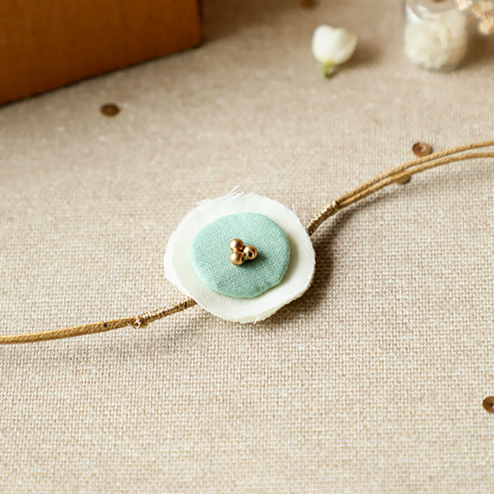 Handmade Reusable Round Layered Petal Beads Upcycled Fabric Rakhi With Roli Chawal For Brother - Close-up View with Blue Detail