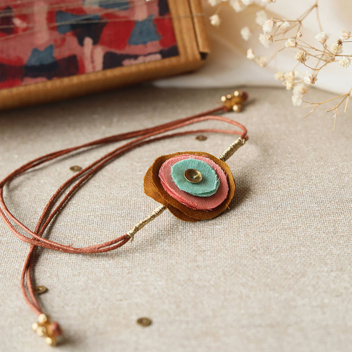 Handmade Reusable Layered Petal And Ghungroo Upcycled Fabric Rakhi With Roli Chawal For Brother - Close-up Front View