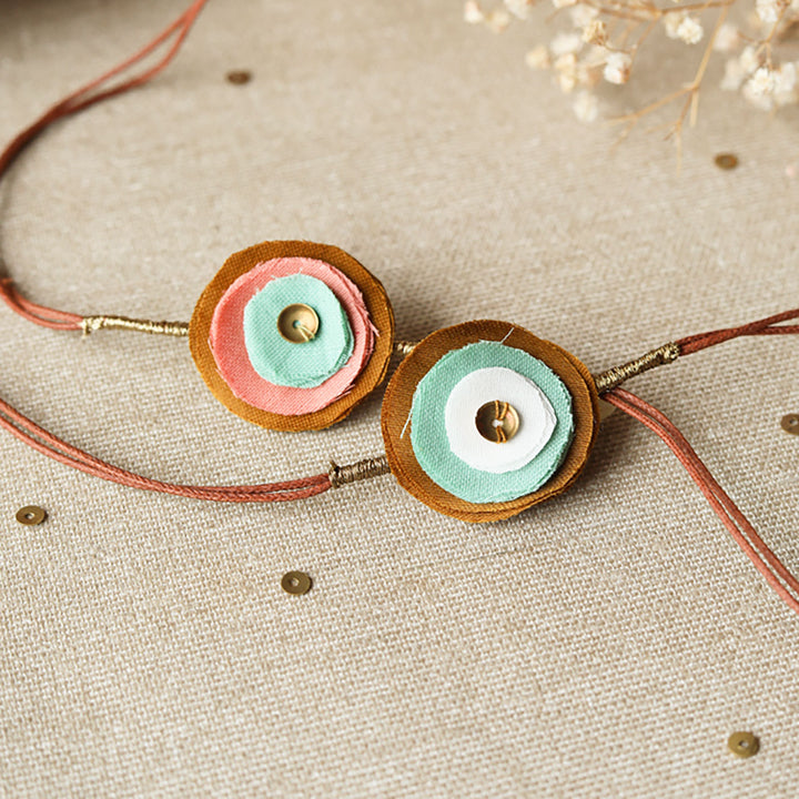 Handmade Reusable Layered Petal And Ghungroo Upcycled Fabric Rakhi With Roli Chawal For Brother Set Of 2 - Front View of Floral Detail