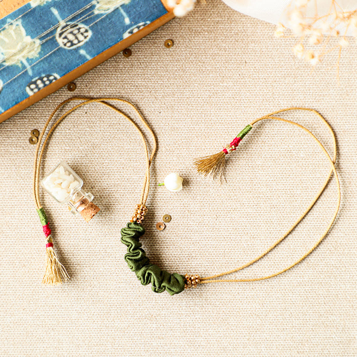 Handmade Reusable Gold Beads And Gathered Upcycled Fabric Rakhi With Roli Chawal For Brother - Flat Lay with Decorative Bottle (6)