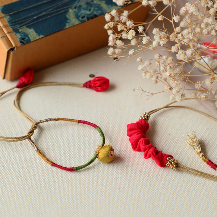 Handmade Reusable Pod And Gathered Upcycled Fabric Rakhi With Roli Chawal For Brother Set Of 2 - Top view of varied bracelets