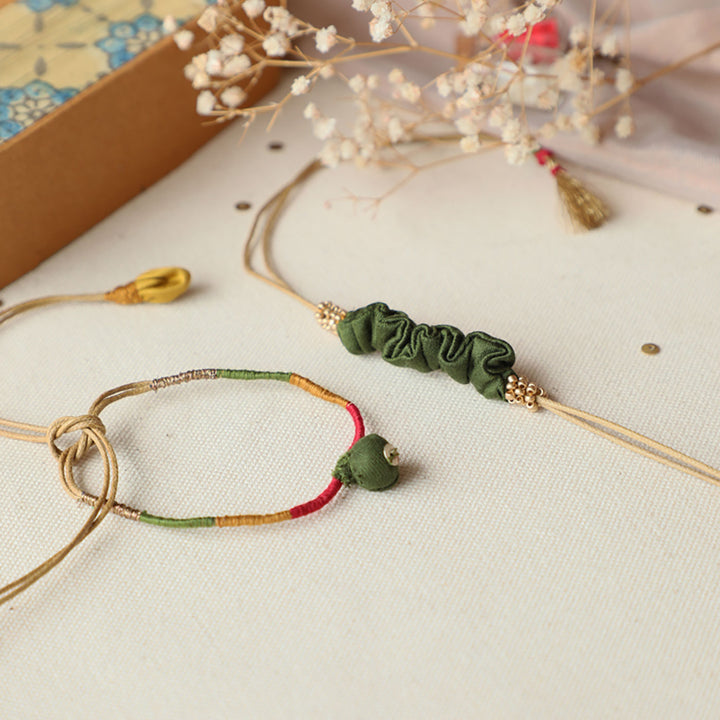 Handmade Reusable Pod And Gathered Upcycled Fabric Rakhi With Roli Chawal For Brother Set Of 2 - Close-up of two bracelets