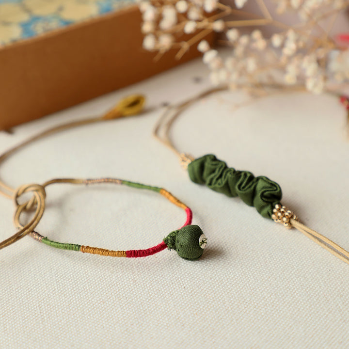 Handmade Reusable Pod And Gathered Upcycled Fabric Rakhi With Roli Chawal For Brother Set Of 2 - Angled close-up of bracelets