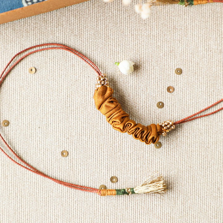 Handmade Reusable Gold Beads And Gathered Upcycled Fabric Rakhi With Roli Chawal For Brother - Close-up Detail View