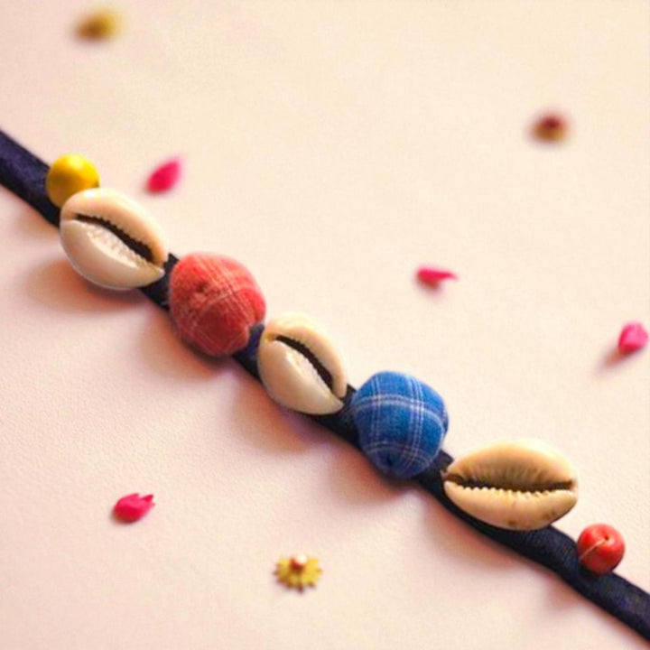 Handmade Beaded Shell Design Upcycled Fabric Rakhi With Roli Chawal For Brother - Close-up with petal accents