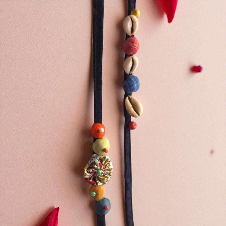 Handmade Beaded Shell Design Upcycled Fabric Rakhi With Roli Chawal For Brother - Close-up of hanging elements
