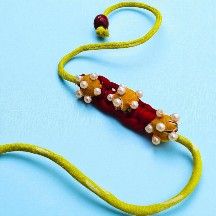 Handmade Golden Coiled Pearl Upcycled Fabric Rakhi With Roli Chawal For Brother - Full Length with Closure Detail