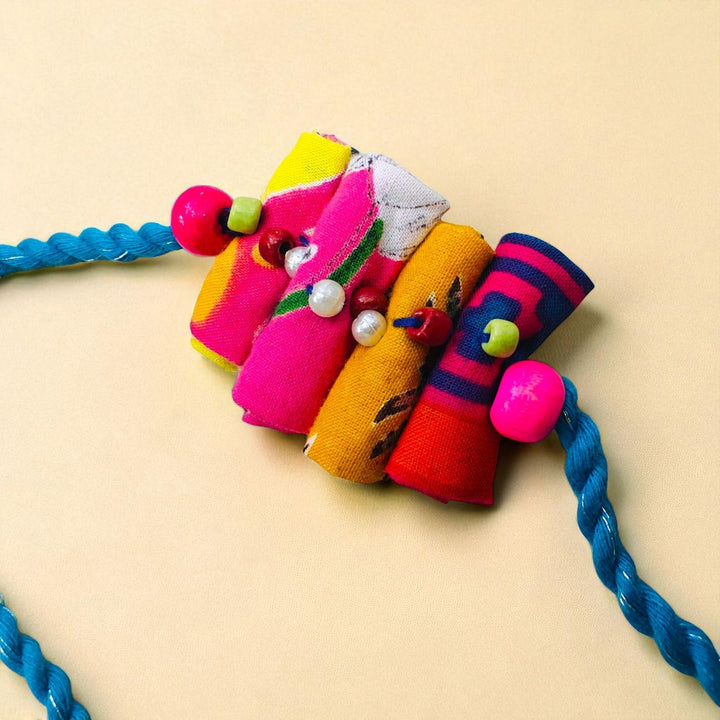 Handmade Beaded Roll Stacked Design Upcycled Fabric Rakhi With Roli Chawal For Brother - Close-up of Pendant Detail