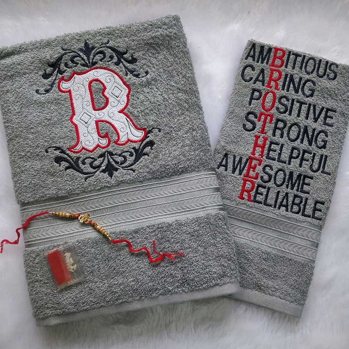 Personalized Embroidered Light Grey Cotton Towel Rakhi Hamper With Roli Chawal For Brother Includes 1 Hand Towel 1 Bath Towel And 1 Rakhi - Towel Front View with Rakhi