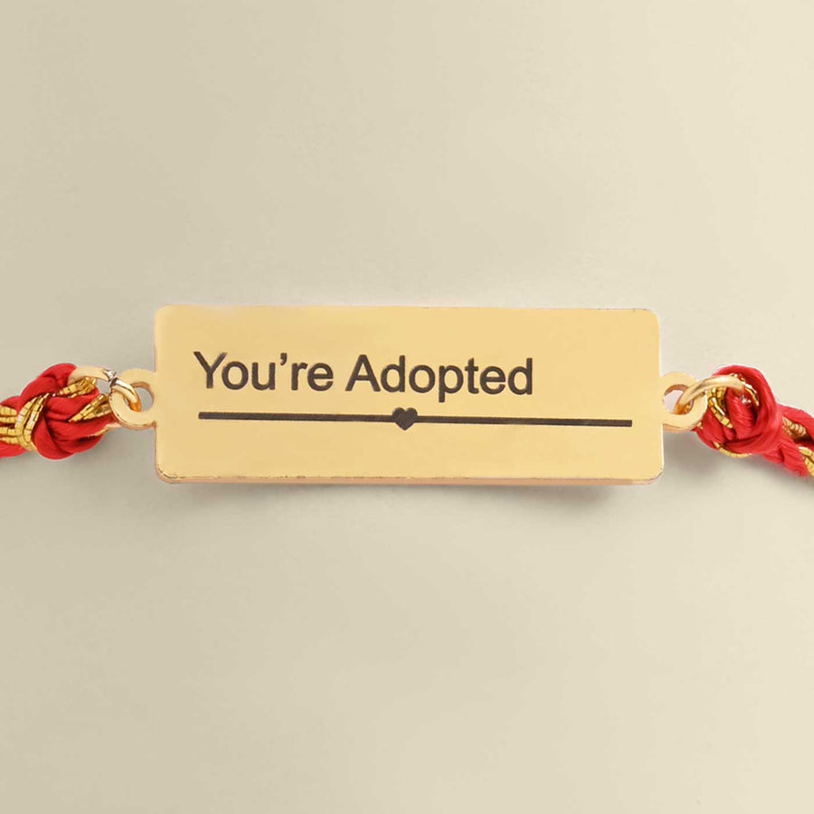 Handmade Youre Adopted Design Metal Rakhi For Siblings - Close-up of Engraving Detail