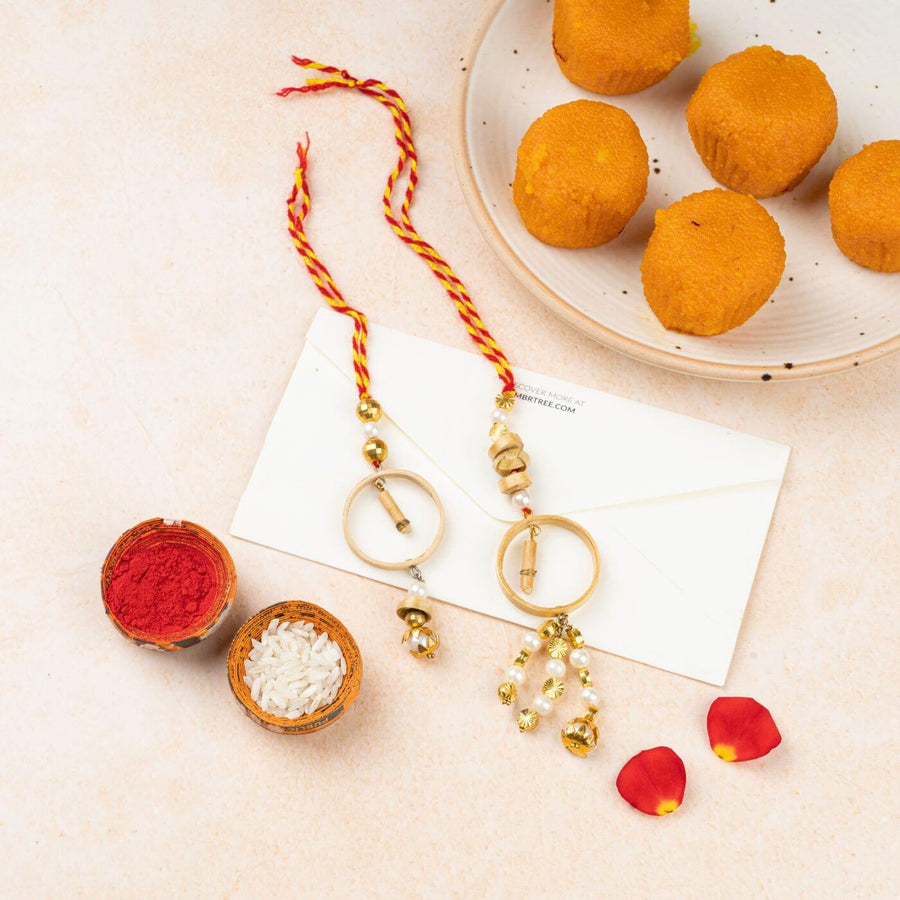 Ecofriendly Bamboo Rakhis For Bhaiya Bhabhi With Roli Chawal 8 - Flat Lay with Rakhi and Sweets