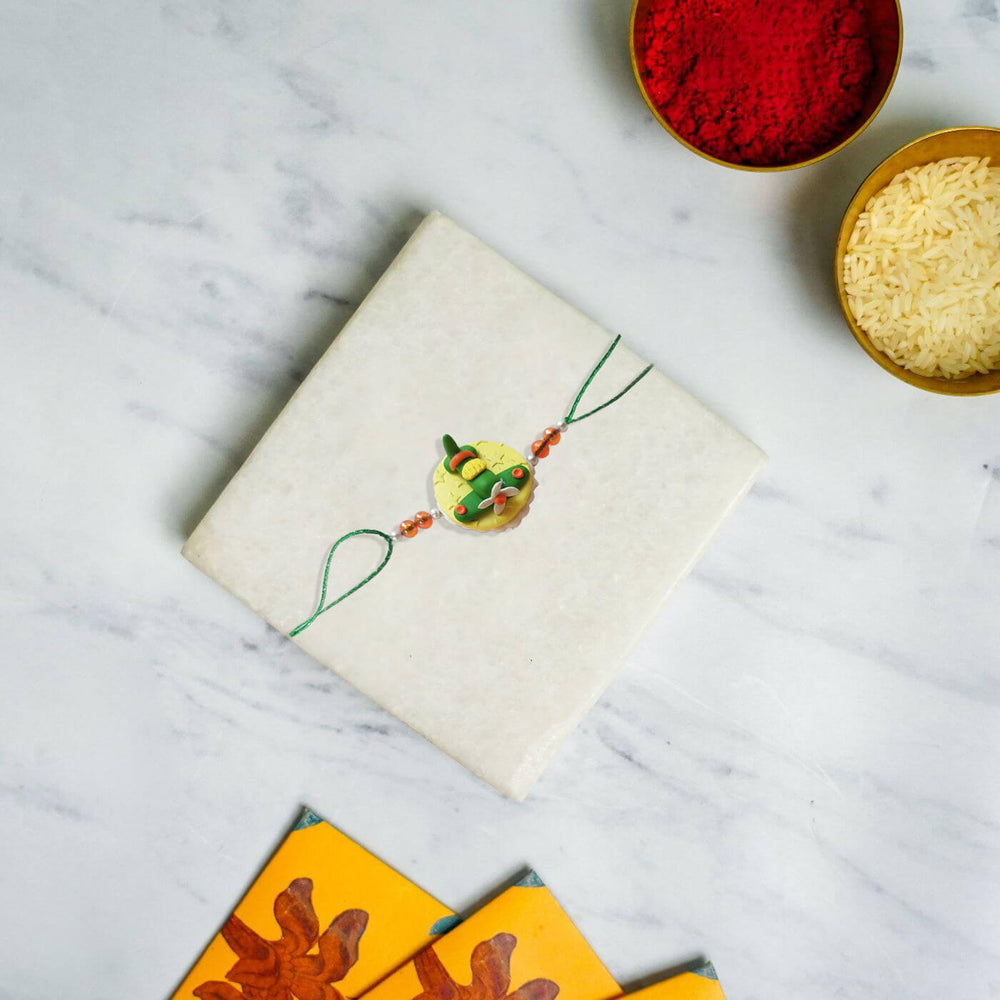 Handmade Porcelain Clay Themed Rakhi 1 - Rakhi on wrapped gift box