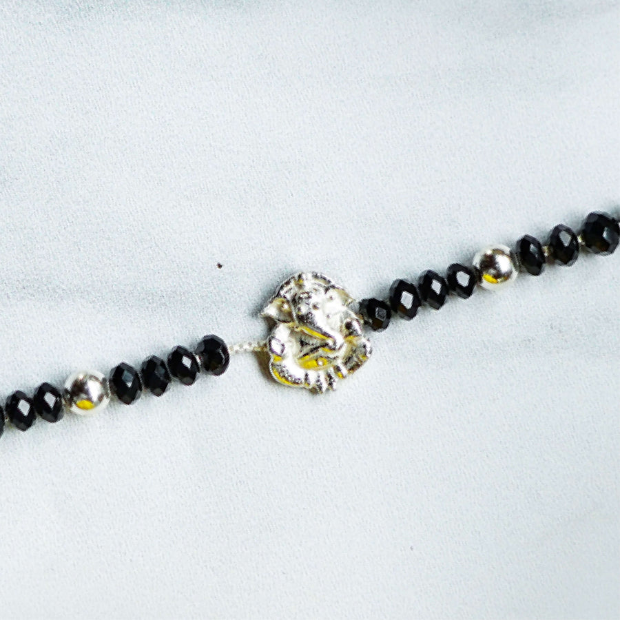 Handcrafted Nazar Battu Silver Ganesha Rakhi For Newborns With Rice Roli - Close-up of Bracelet Centerpiece