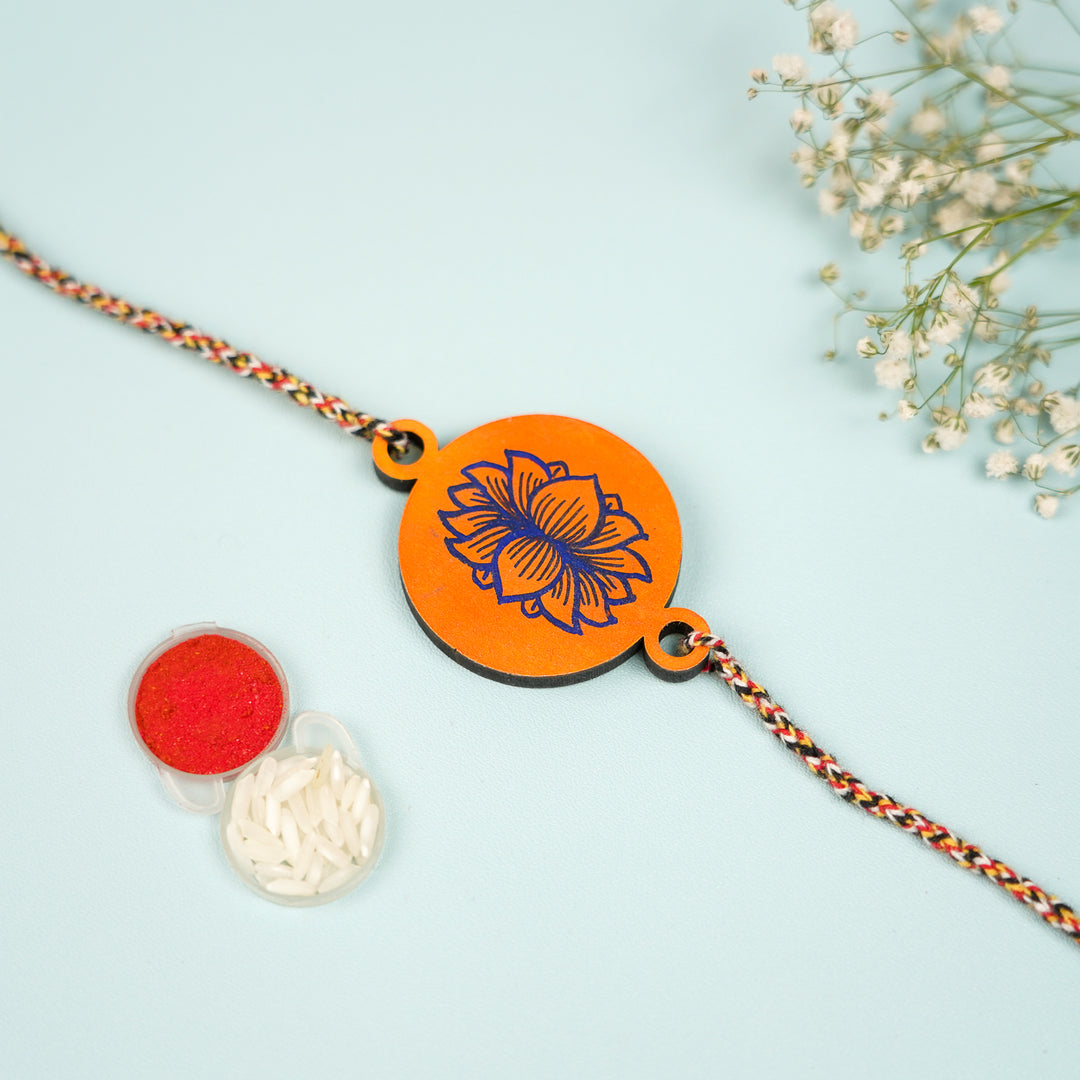 Hand Painted Pattachitra Orange Lotus Design Wooden Rakhi With Roli Chawal For Brother - Front View with Accessories
