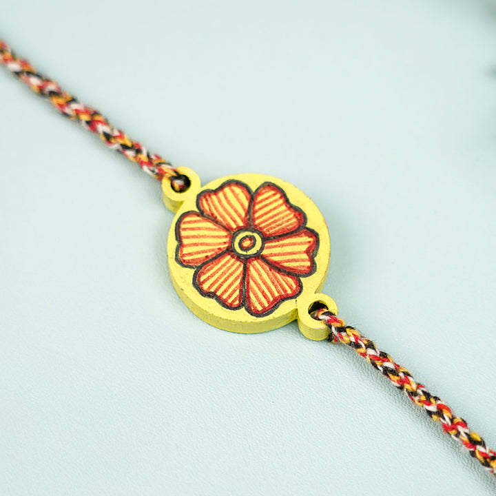 Hand Painted Madhubani Yellow Flower Design And Beads Wooden Rakhi With Roli Chawal For Brother - Close-up of Flower Charm