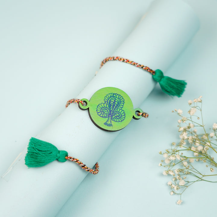 Hand Painted Pattachitra Peacock Feather Design Wooden Rakhi With Roli Chawal For Brother - Styled on rolled paper with tassels