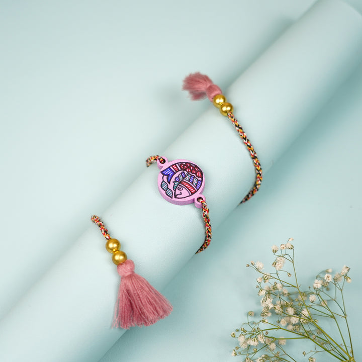 Hand Painted Madhubani Fish Design Beads Wooden Rakhi With Roli Chawal For Brother - Wrapped Around Cylindrical Display