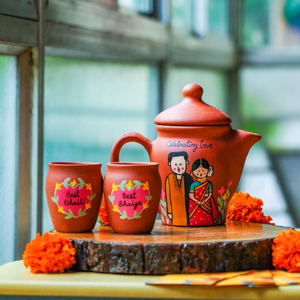 Terracotta Caricatures Teaset For Bhaiya Bhabhi With Rakhi - Styled Product Display on Wooden Slab