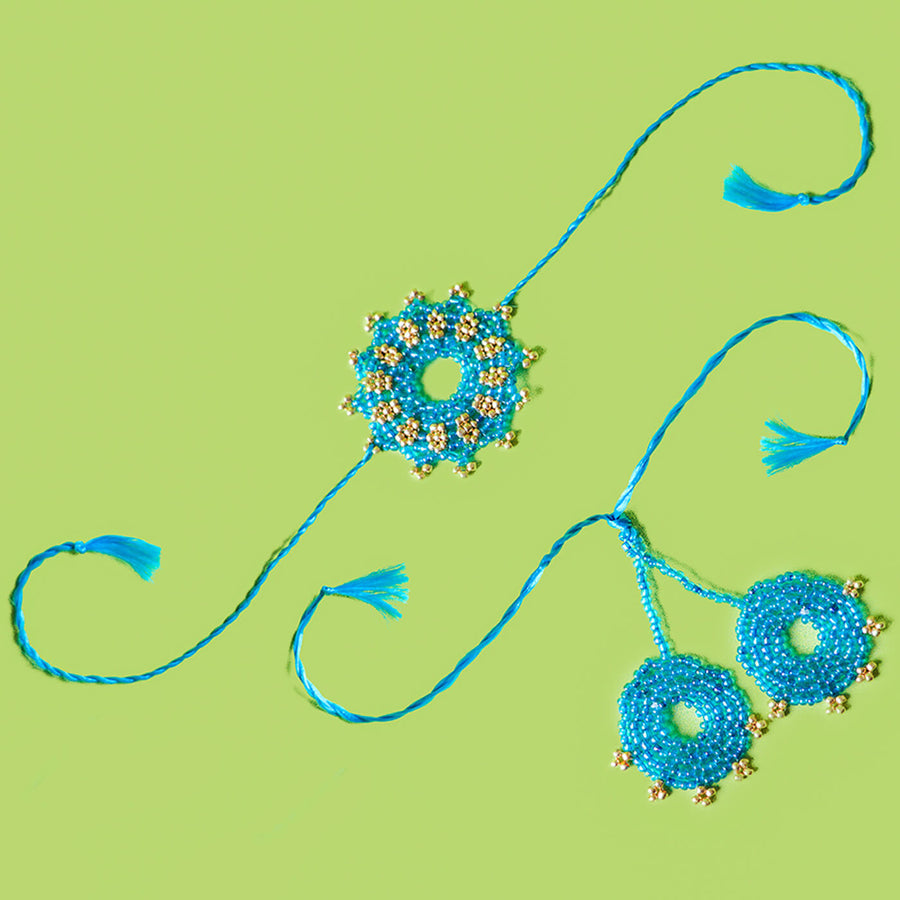 Handcrafted Bhaiya Bhabhi Round Rakhi Set Blue - Pair Display on Green Background
