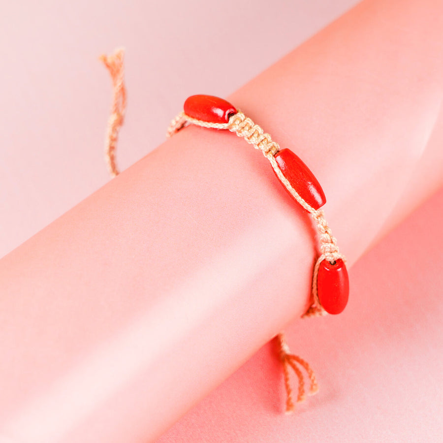 Pink Macrame Cotton Rakhi With Red Beads - Close-up of bracelet on wrist