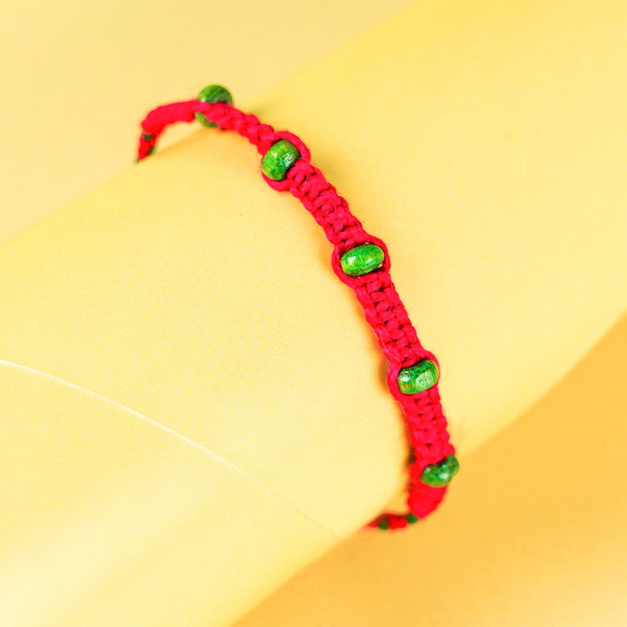 Red Macrame Cotton Rakhi With Green Beads - On Wrist Close-up