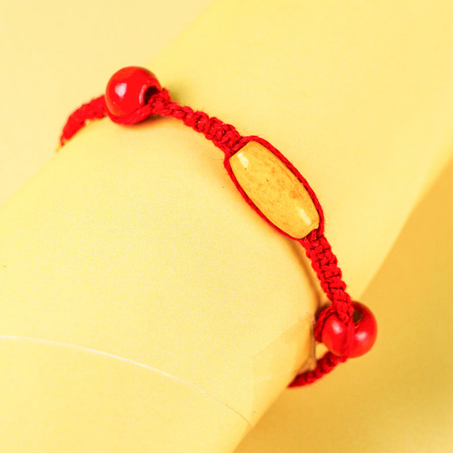 Red Macrame Cotton Rakhi With Red Yellow Beads - Close-up of Bracelet on Wrist