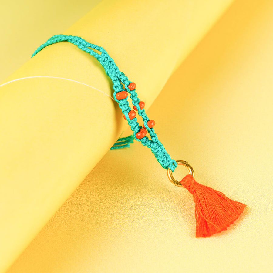 Teal Macrame Cotton Rakhi With Orange Beads Tassle - Close-up of bracelet with tassel
