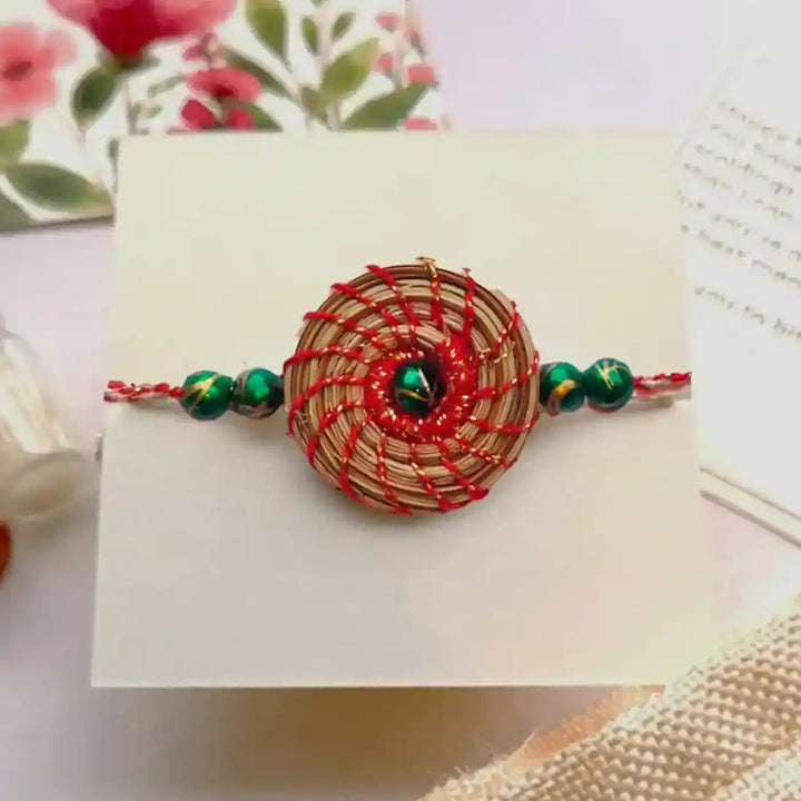 Eco Friendly Handmade Green Breads Pine Needle Rakhi With Pouch And Roli Chawal - Close-up Front View
