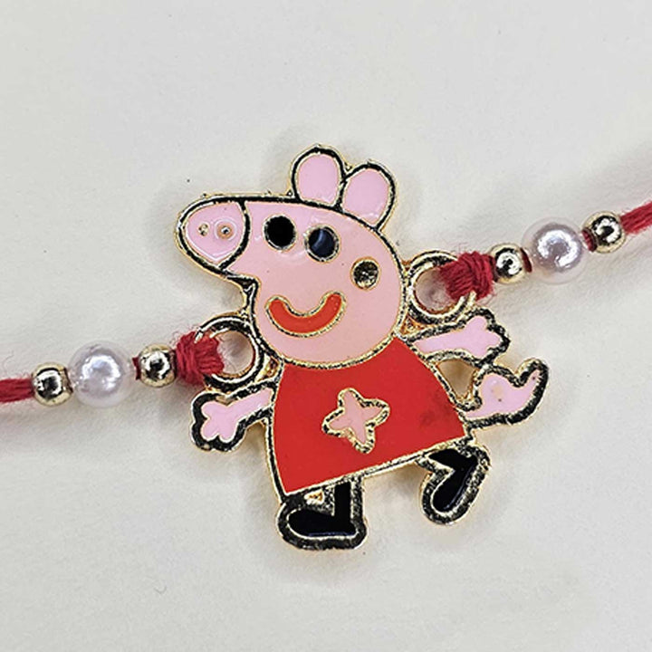 Handmade Peppa Pig Theme Metal Kids Rakhi With Roli Chawal - Close-up of Charm Detail