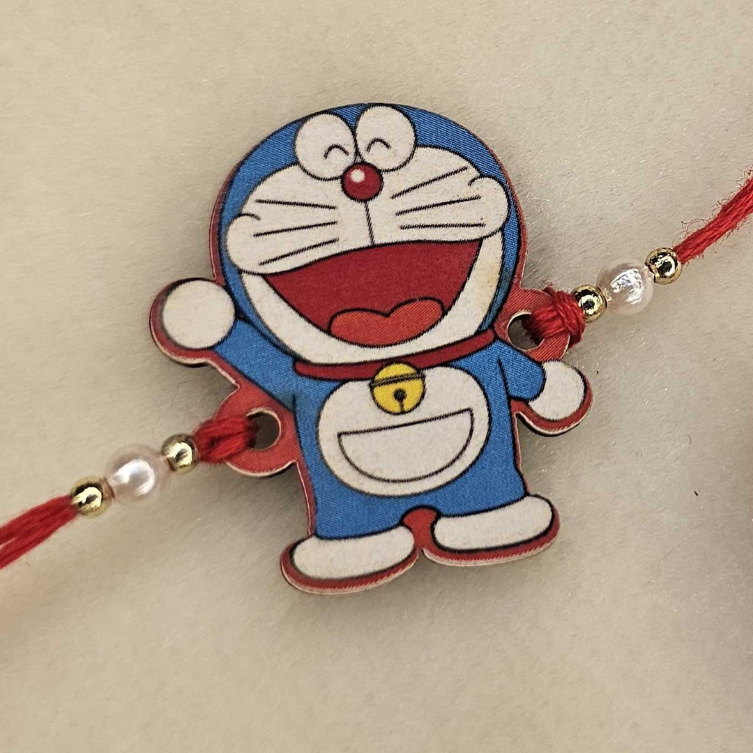 Handmade Doraemon Mdf Wood Kids Rakhi With Roli Chawal - Angled Close-up View