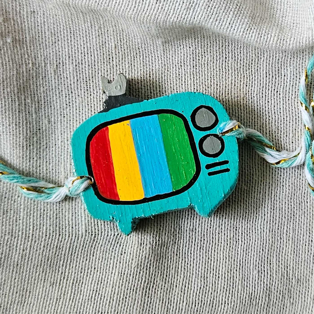 Handpainted Quirky Wooden Rakhi With Roli Chawal 7 New - Close-up of TV charm