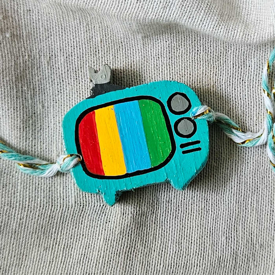 Handpainted Quirky Wooden Rakhi With Roli Chawal 7 New - Close-up of TV charm