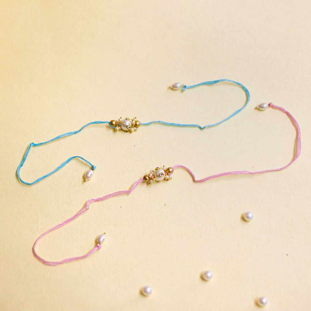 Handmade Basra Pearl Rakhi With Roli Chawal - Flat lay with scattered pearls