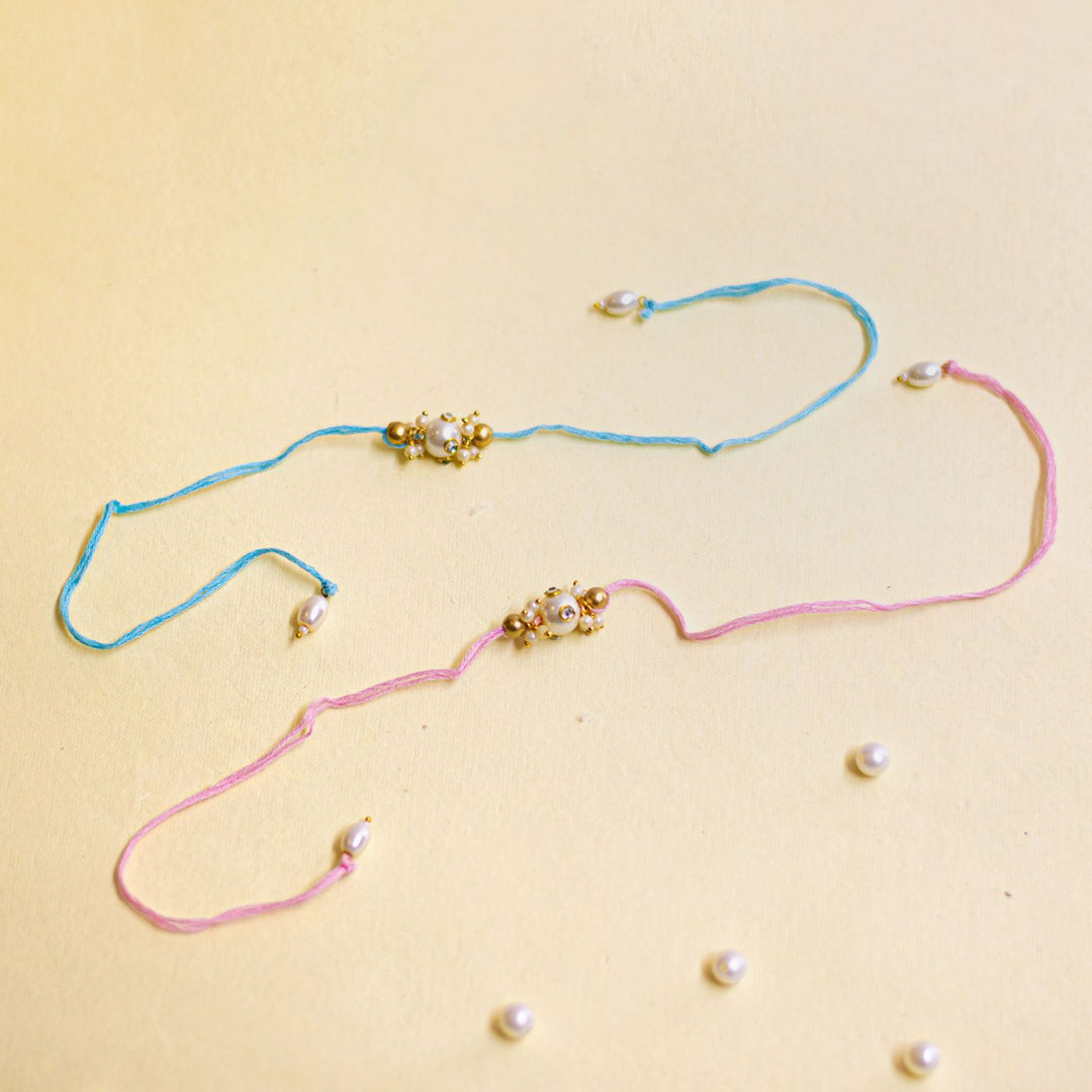 Handmade Basra Pearl Rakhi With Roli Chawal - Flat lay with scattered pearls
