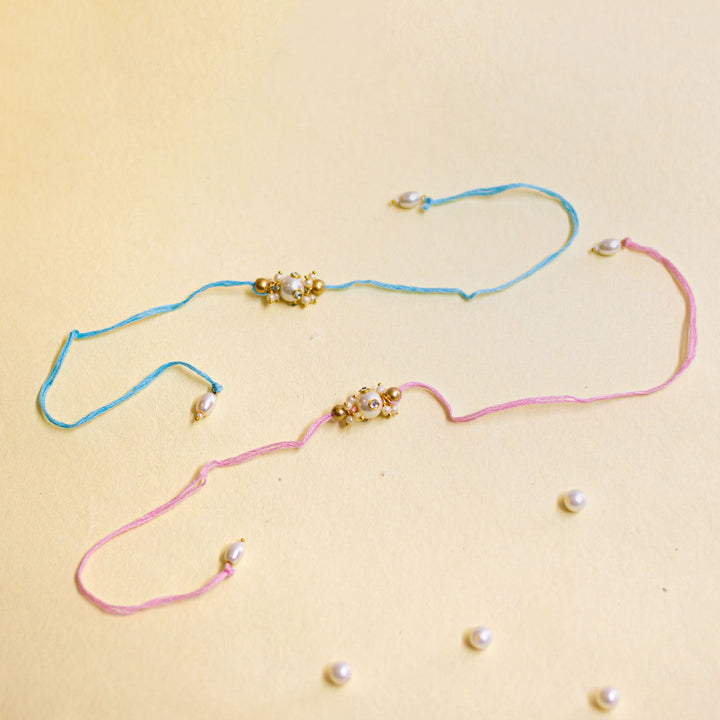 Handmade Basra Pearl Rakhi With Roli Chawal - Flat lay with scattered pearls