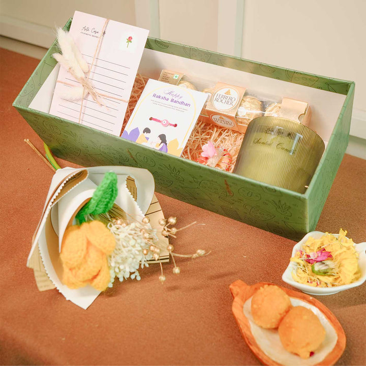 Personalized Handmade Crochet Flower Lover Rakhi Hamper Includes 1 Gift Box 1 Crochet Flower 1 Rakhis 1 Roli Chawal 1 Candle And 1 Message Card - Angled View of Gift Set