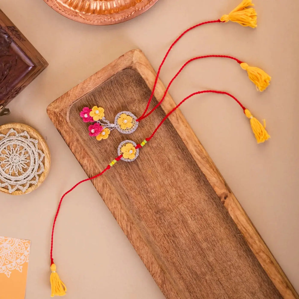 Handmade Crochet Golden Daisy Bhaiya Bhabhi Rakhi With Roli Chawal Set Of 2 - Flat Lay with Decor Items