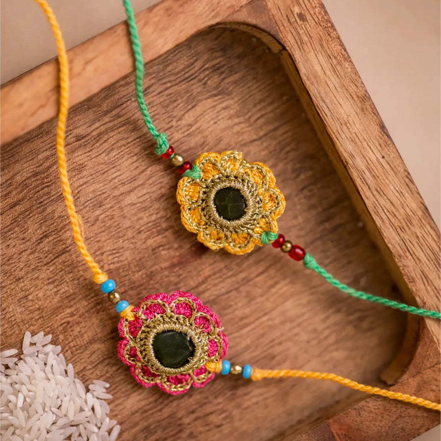 Handmade Crochet Green And Red Kundan Rakhi With Roli Chawal Set Of 2 - Close-up of two bracelets