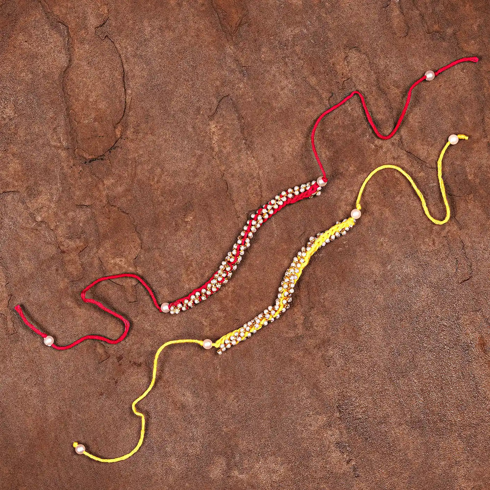 Handmade Crochet Pearl Rakhi With Roli Chawal Set Of 2 - Flat Lay with Extended Strings