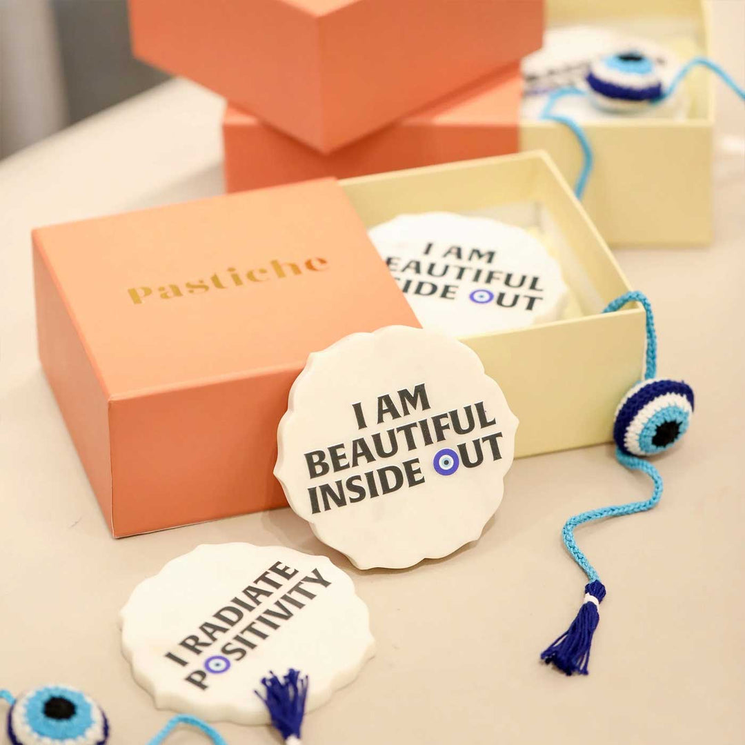Handmade Crochet Evil Eye Design Cotton Rakhi Hamper Includes 1 Rakhi And 4 Coaster - Coasters Displayed beside Packaging Box