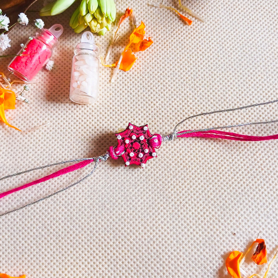 Handmade Pink Star Design Beads Wooden Rakhi With Roli Chawal For Brother - Laid Flat with Decorative Items