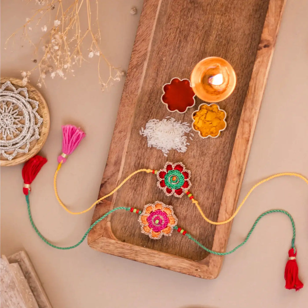 Handmade Crochet Champa Rakhi With Roli Chawal Set Of 2 - Styled Flat Lay with Ritual Elements
