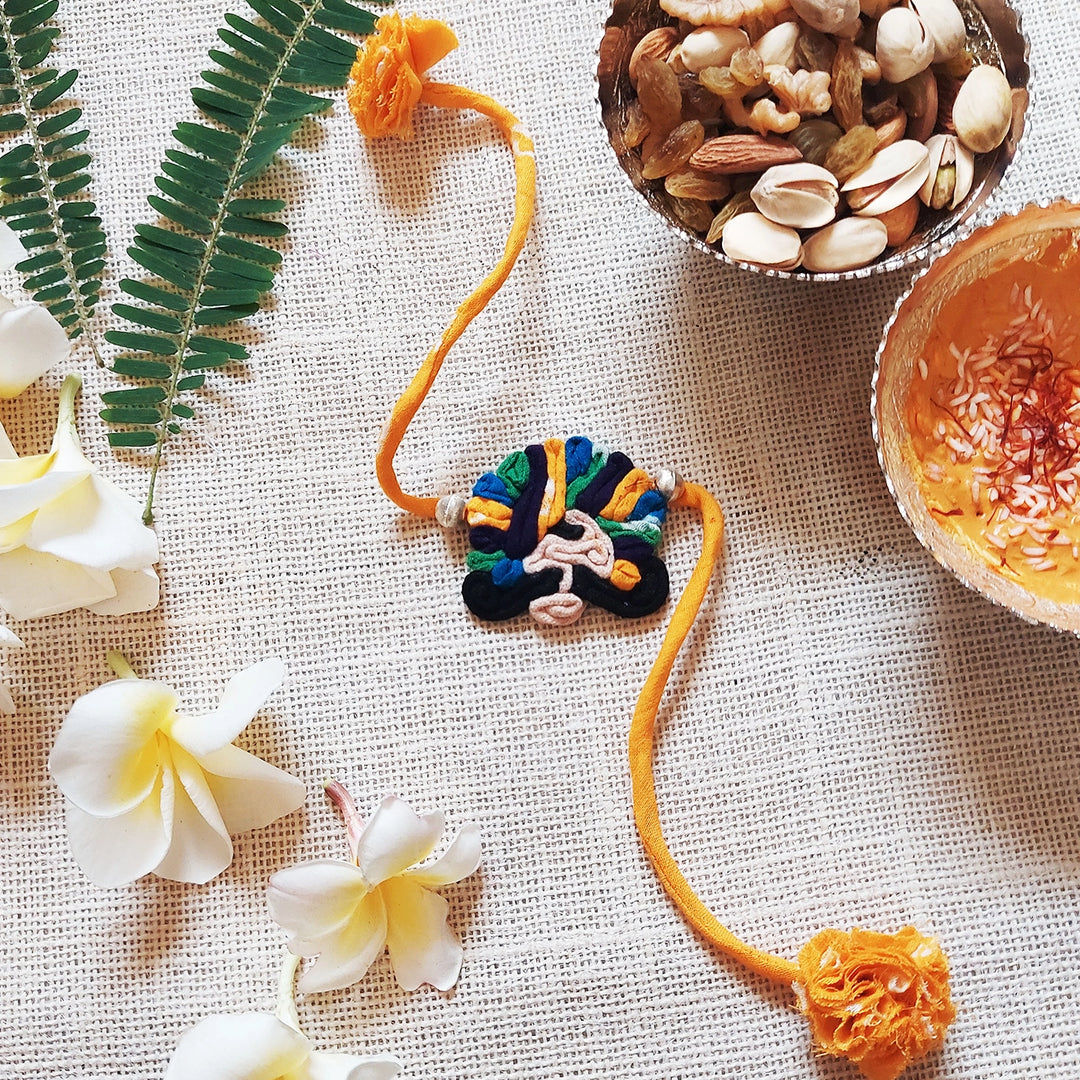 Handmade Dori Work Ethnic Rabari Rakhi With Roli Chawal - Decorative Orange Thread Bracelet Display